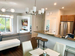 Bright open-concept living with kitchen bar & balcony access